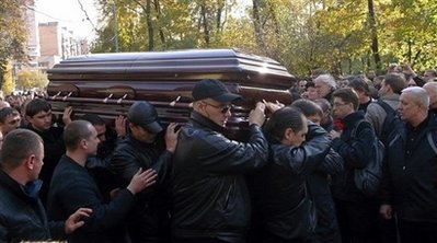 Неопознанные личности несут гроб с телом Япончика. Фото AP