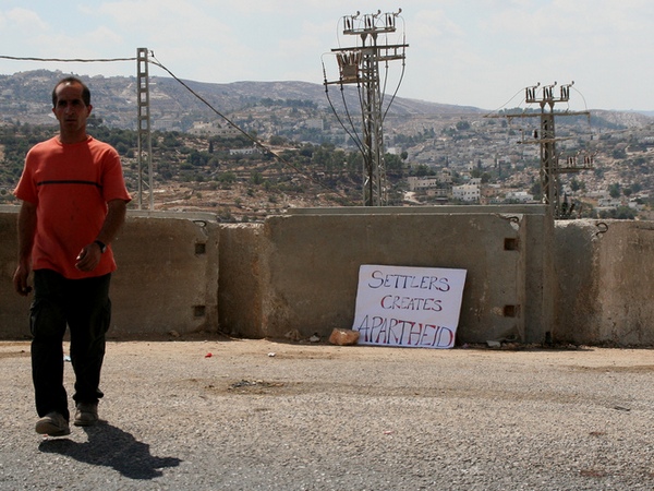 Надпись на плакате: «Поселенцы порождают апартеид»