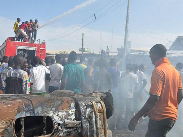 Пожарные тушат огонь на месте теракта в Майдугури, Нигерия