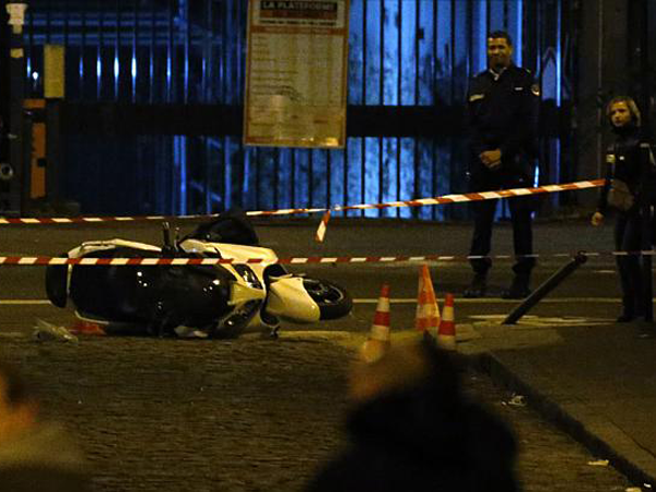 Парижские полицейские рядом с брошенным грабителями мотороллером