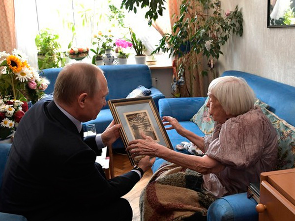В.Путин дарит Л.Алексеевой гравюру с изображением пейзажа Евпатории.